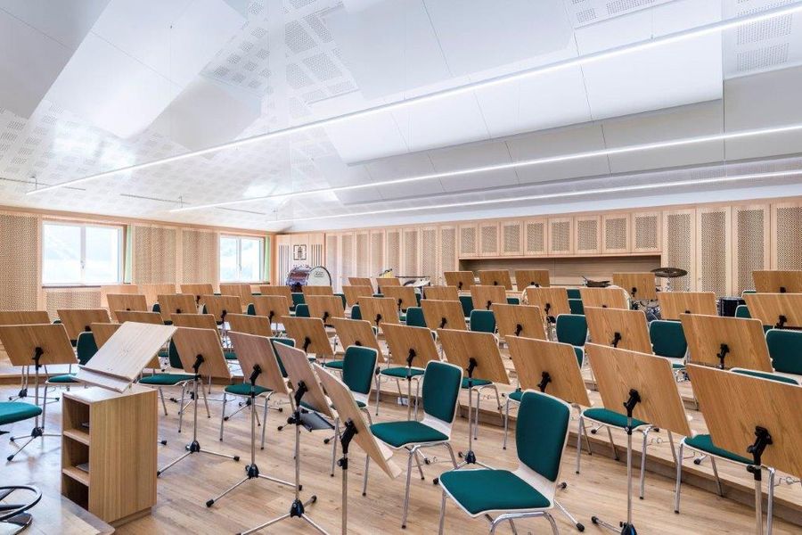 Musikprobelokal mit Holzverkleidung, gelochten Akustikplatten und Notenständern
