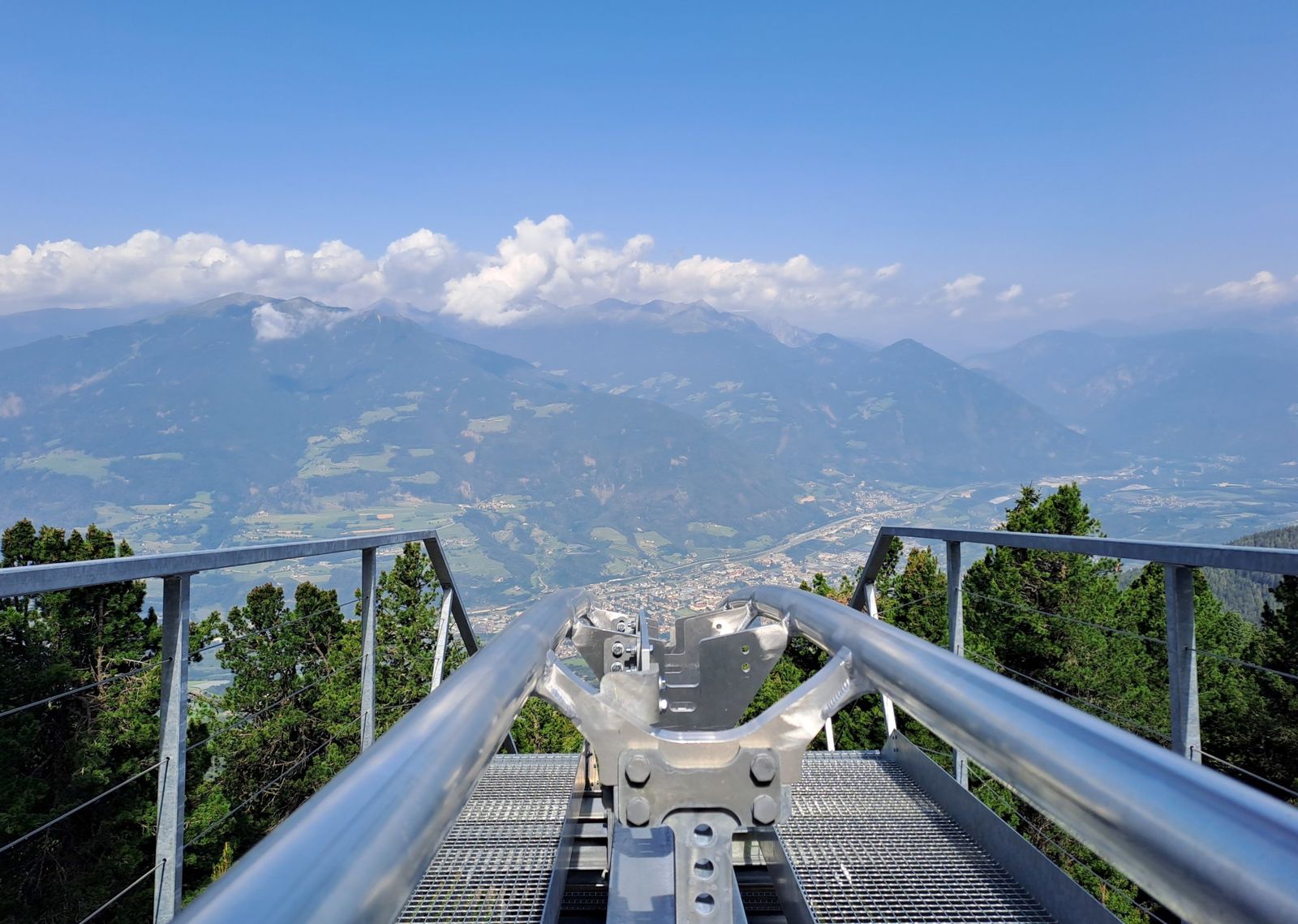 Startbereich der Sommerrodelbahn Plosebob mit Schienen und Blick hinunter auf Brixen